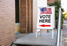 Sidewalk sign with American flag directing to a polling place