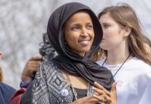 Ilhan Omar’s Minneapolis Fortress Still Looks Impenetrable woman in a black headscarf at an outdoor gathering
