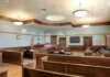Who Deserves Our Sympathy In This Tragedy? Empty courtroom with wooden benches and judge's bench