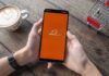 Person holding smartphone with Alibaba app on screen
