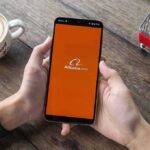 One Bluetooth Glitch Uncovered A Privacy Surprise Person holding smartphone with Alibaba app on screen