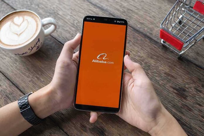 Person holding smartphone with Alibaba app on screen