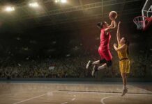 Two basketball players contest a layup under the hoop