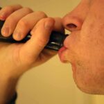 Terrifying Youth Liver Surge — What’s Driving It? Person drinking from a dark bottle close-up