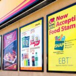 Store window posters advertising SNAP EBT acceptance and product deals