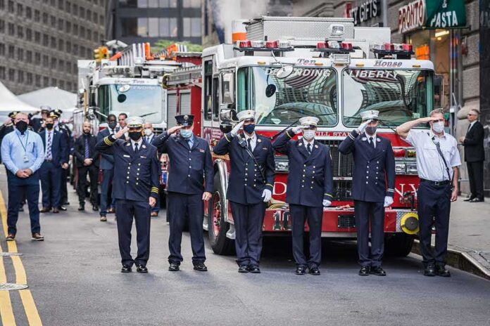 shutterstock_1813535977 Firefighters in dress uniforms salute in front of fire trucks
