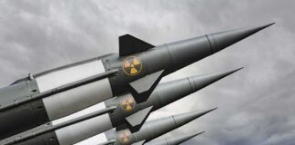 Four military missiles with radiation symbols pointed skyward
