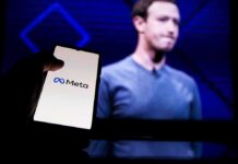 smartphone showing Meta logo in front of a blurred speaker on stage