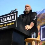 Bipartisan Pact Rattles Pennsylvania Speaker at outdoor rally standing at podium with microphone