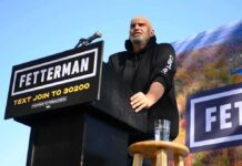 Speaker at outdoor rally standing at podium with microphone