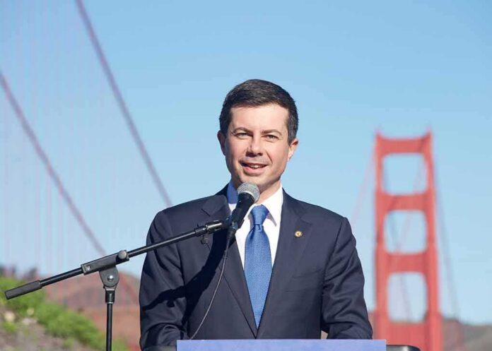 shutterstock_2253311909 man in suit speaking at a microphone near a red suspension bridge
