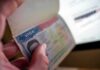 Hand holding a passport with a visa page