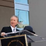 Hollywood Clash: Islam Debate Turns Volatile A man in formal attire speaking at a podium during a Hollywood Walk of Fame ceremony