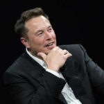 Three Outsiders Just Got a Pentagon Mission Elon Musk speaking on stage in a dark suit, resting his chin on his hand