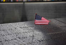 American flag on a rainy memorial nameplate.