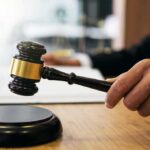 Shocking Release: Murder Suspect Walks Judge's hand holding a gavel over a sound block