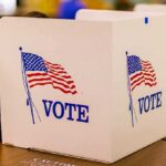 Texas Crackdown Snags Noncitizen Ballots voting booth with American flag graphics