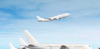 Commercial airplanes at airport with one taking off