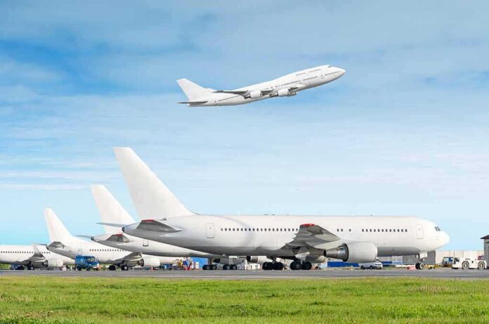 shutterstock_1076562266 Commercial airplanes at airport with one taking off