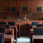Shocking Arraignment Looms for Top Influencer Empty courtroom with wooden benches and judge's bench
