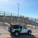 Directed Energy Flips The Border Game Border patrol SUV parked by tall metal fence near the coast