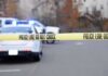 A Federal Shooting Leaves One Crucial Blind Spot Police tape cordons off a street with patrol cars and flashing lights in the background