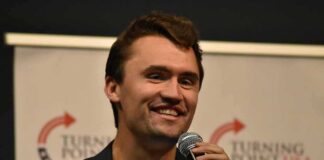 man speaking into a microphone on stage
