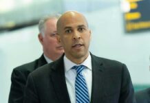 man in suit speaking at a microphone