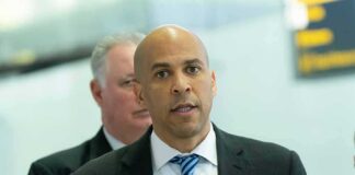 man in suit speaking at a microphone