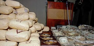 Seized packages, cash, and handguns on a table
