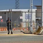 Night Clashes, Sudden Arrests — Newark Boils Security guard at chain-link gate of fenced facility