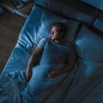 Sleep Upgrade Slashes 83 Risks Man lying in bed at night looking toward window