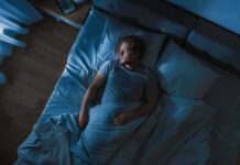 Sleep Upgrade Slashes 83 Risks Man lying in bed at night looking toward window