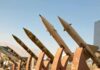 Row of surface-to-surface missiles mounted on display stands outdoors