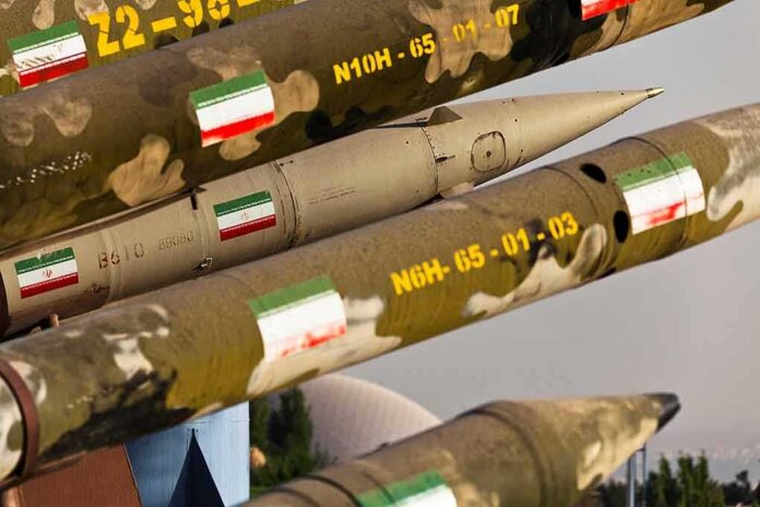 Row of military missiles with camouflage and national flags
