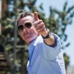 Newsom Cries Politics As DOJ Probe Expands man in sunglasses giving a thumbs-up outdoors