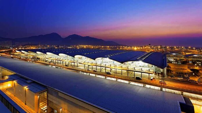 Airport terminal at dusk with illuminated wave-like roof