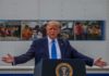 Donald Trump speaks at a podium with arms outstretched