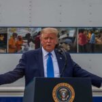 Media Showdown Spurs ‘Trump TV’ Blitz Donald Trump speaks at a podium with arms outstretched
