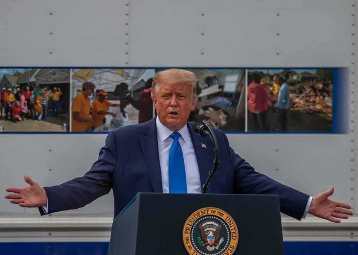 Donald Trump speaks at a podium with arms outstretched