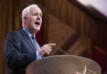 Elderly man in suit speaking at a podium