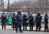Five Arrests Put A Key Airbase On Alert Group of police officers in riot gear standing on a street; Brian Folkerts present