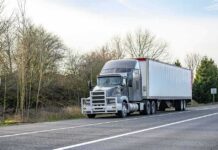 Semi-truck parked on roadside with trailer