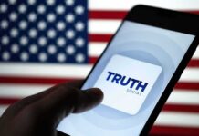 Smartphone displaying Truth Social app against an American flag backdrop