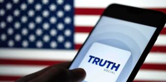 Smartphone displaying Truth Social app against an American flag backdrop