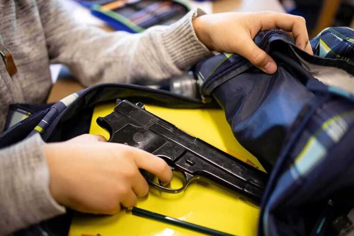 hand reaches into backpack with a handgun inside