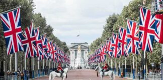 Union Jack flags line a broad avenue with mounted guards