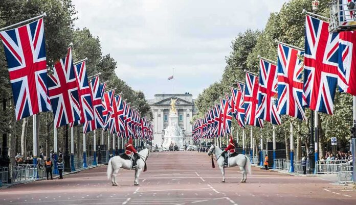 Union Jack flags line a broad avenue with mounted guards