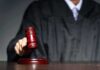 Judge with gavel striking sound block