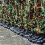 Row of soldiers in camouflage pants and black boots